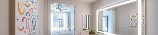 a bathroom with a sink and a mirror and a door to a bedroom