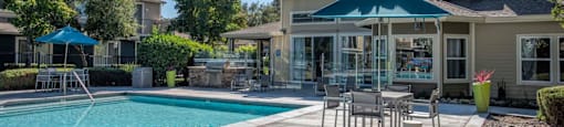 Swimming Pool Area With Shaded Table And Chairs at Atwood Apartments, Citrus Heights, CA