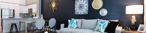 a living room with a gray couch and blue and white pillows
