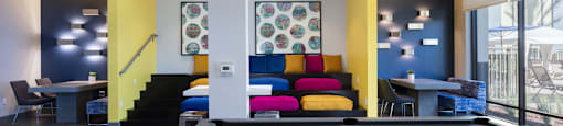 a pool table with a colorful couch in the background
