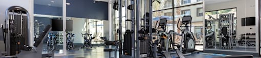 a gym with a lot of exercise equipment and a large window