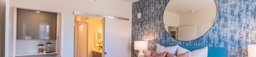 a bedroom with a large bed and a mirror on the wall