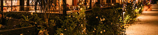A restaurant named Buona Ferretti is lit up at night with lights and decorations.
