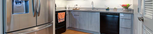 a kitchen with stainless steel appliances and a wooden floor
