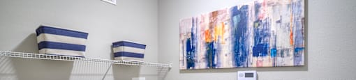 a washer and dryer in a laundry room with a painting on the wall