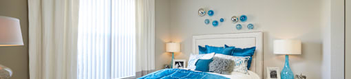a bedroom with a large bed and blue and white bedding