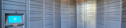 a bunch of blue lockers in a room with a coin machine