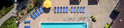 arial view of a swimming pool with blue and yellow umbrellas around it