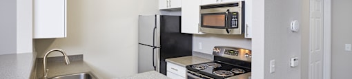 a kitchen with stainless steel appliances and white cabinets