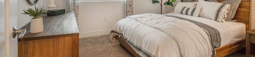 a bedroom with a bed and a dresser and a window