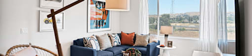 a living room with a blue couch and a large window