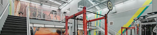 a view of the gym with weights machines and stairs