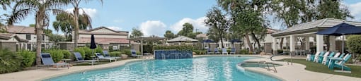 a resort style pool with chairs and umbrellas