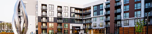 a street view of an apartment complex with a monument in the middle
