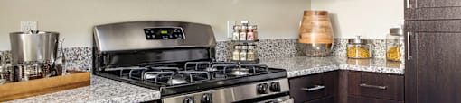 A modern kitchen with dark wood cabinets and stainless steel appliances.