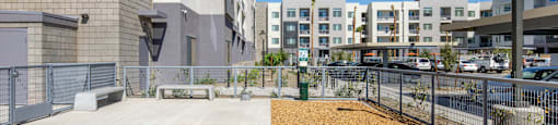 a large building with a sidewalk and a fence in front of it