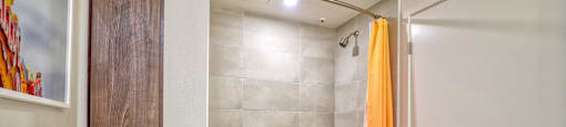 a bathroom with a shower and a tub and a white door
