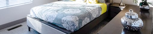 a bedroom with a bed and a night stand and a window