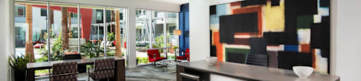 a communal area with a table and chairs and a counter with chairs