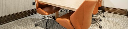 a coworking space with a wooden table and leather chairs