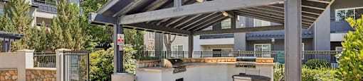 a patio with a grill and a table and chairs