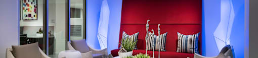a lounge room with white chairs and a red couch