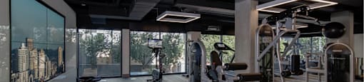a rendering of a fitness room with weights machines and a large window