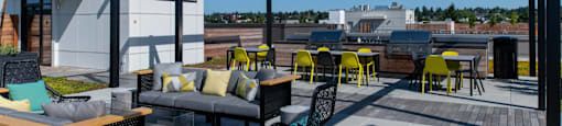 a rooftop patio with tables and chairs and a canopy