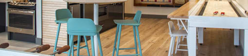 a kitchen with a bar and a table with blue stools