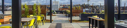the roof terrace with tables and chairs and a view of the city