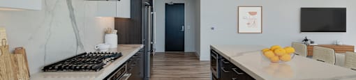 a large kitchen with marble counter tops and wooden floors