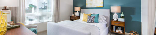 bedroom with white bed and large window