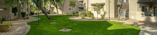 an apartment building with green grass and trees