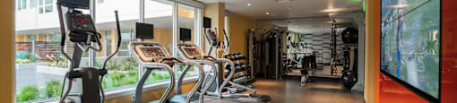 fitness center with cardio equipment and large windows