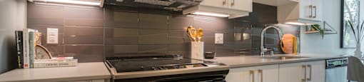a kitchen with white cabinets and a stove and a microwave