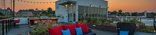 a rooftop patio with furniture and a building in the background