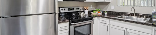 a kitchen with stainless steel appliances and white cabinets