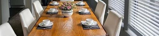 A dining room with a wooden table set for six.