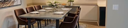 A modern dining room with a large table and chairs.