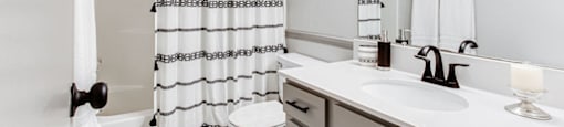 A white bathroom with a toilet, sink, and shower.at Laurel, Union City, GA 30291  