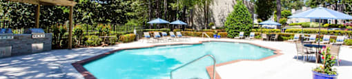 A pool surrounded by trees and chairs.at Laurel, Union City, GA 30291  