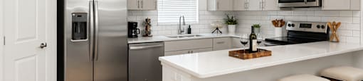 A kitchen with a white island and stools.