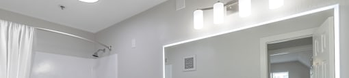 a bathroom with a large mirror and a sink and a toilet at Nobel Court, San Diego, California
