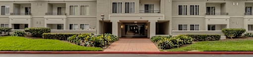 a large apartment building with a blue sky in the background at Nobel Court, San Diego, CA