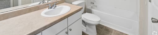 A white bathroom with a sink, toilet, and bathtub.