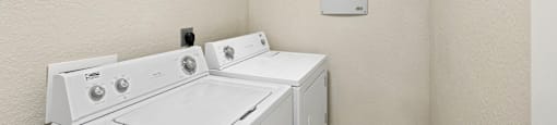 A white washer and dryer in a small laundry room.