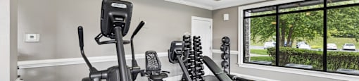 A home gym with a treadmill, elliptical trainer, and a stationary bike.