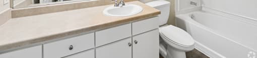 A bathroom with a sink, toilet, and bathtub.