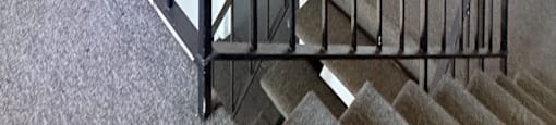 A staircase with a metal railing and a hanging light fixture.