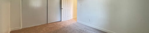 A room with a carpeted floor and a sliding door.